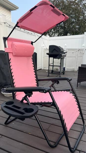 Zero-gravity patio chair with adjustable canopy and cup holder featured on a deck