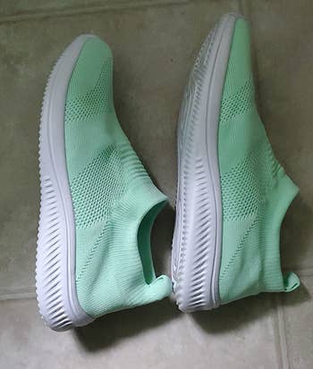 reviewer photo of the light green slip-ons 