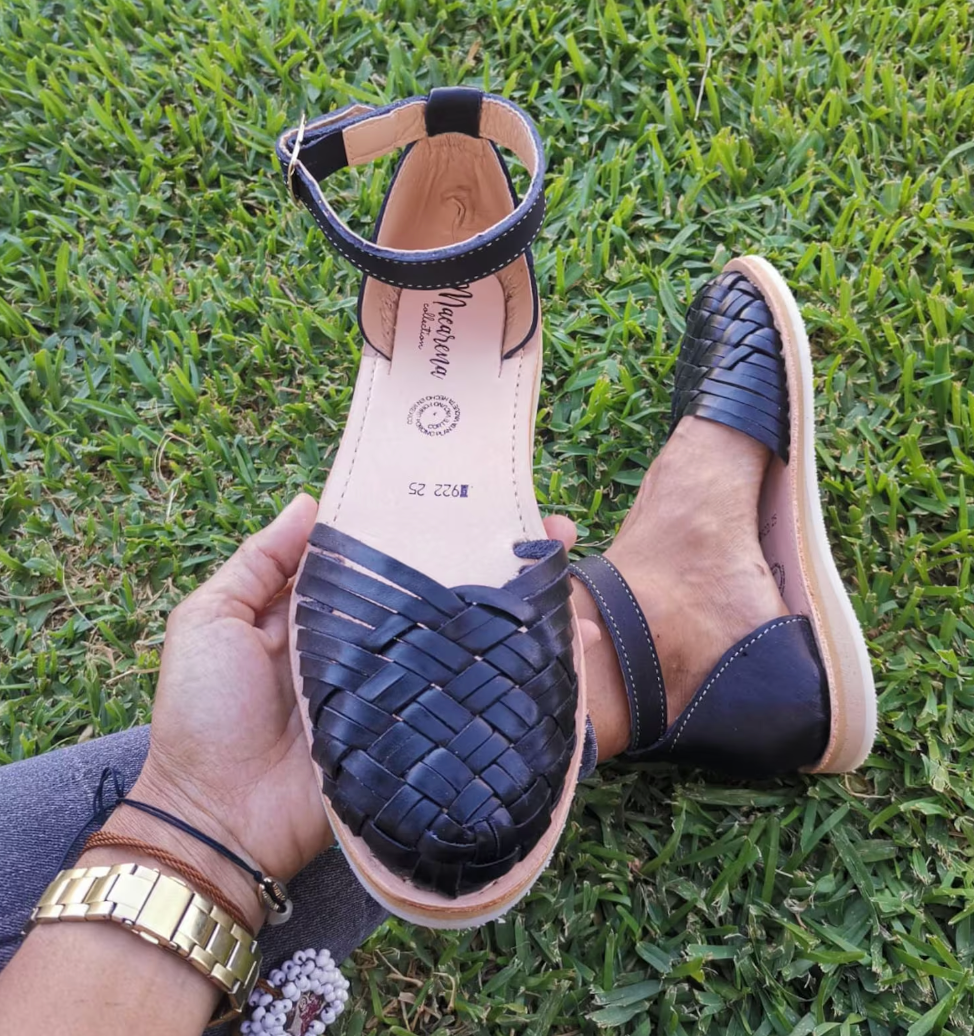model holding a black huarache sandal