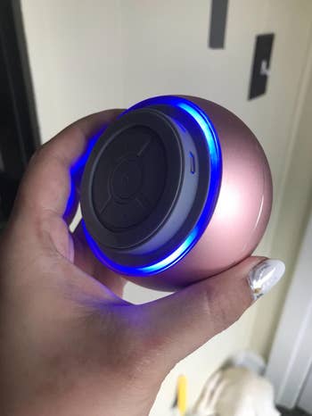 the same reviewer holding the speaker from a different angle