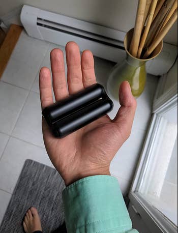 Reviewer holding the black version of it in their palm 