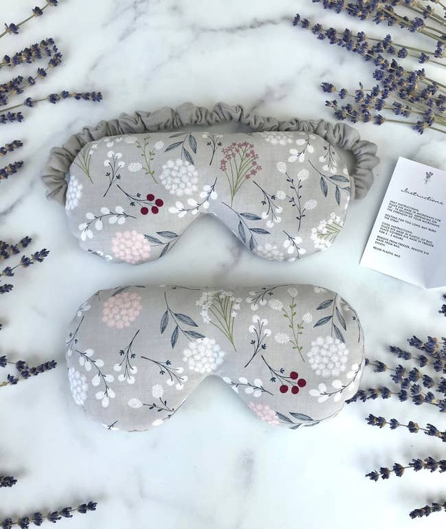 A gray eye mask with floral designs on it 