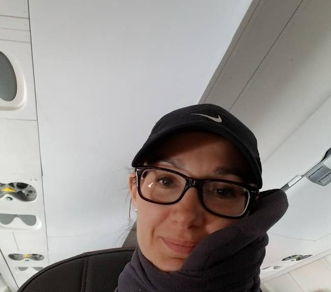 reviewer wearing travel pillow on a plane