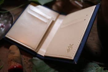the open wallet with four card slots, a slip pocket, and a small embossed beet in the lower right corner