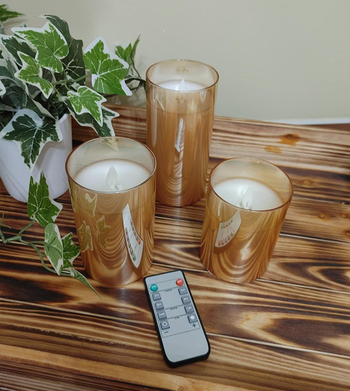 reviewer image of three unlit candles in different sizes with a small remote 