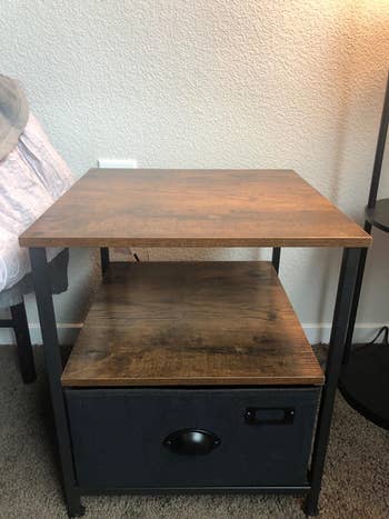 reviewer photo of wooden nightstand next to bed