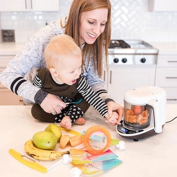 a mother and child making baby food in a baby brezza baby food maker