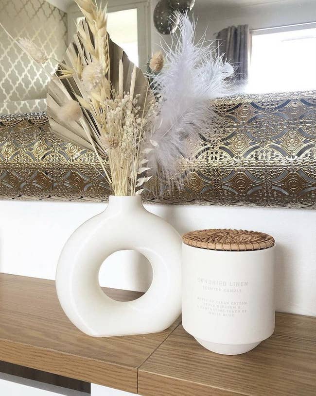 the white nordic donut vase next to a candle