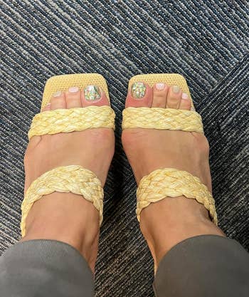 Feet in yellow braided slide sandals