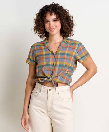 Woman in a tied-front plaid shirt and high-waisted pants