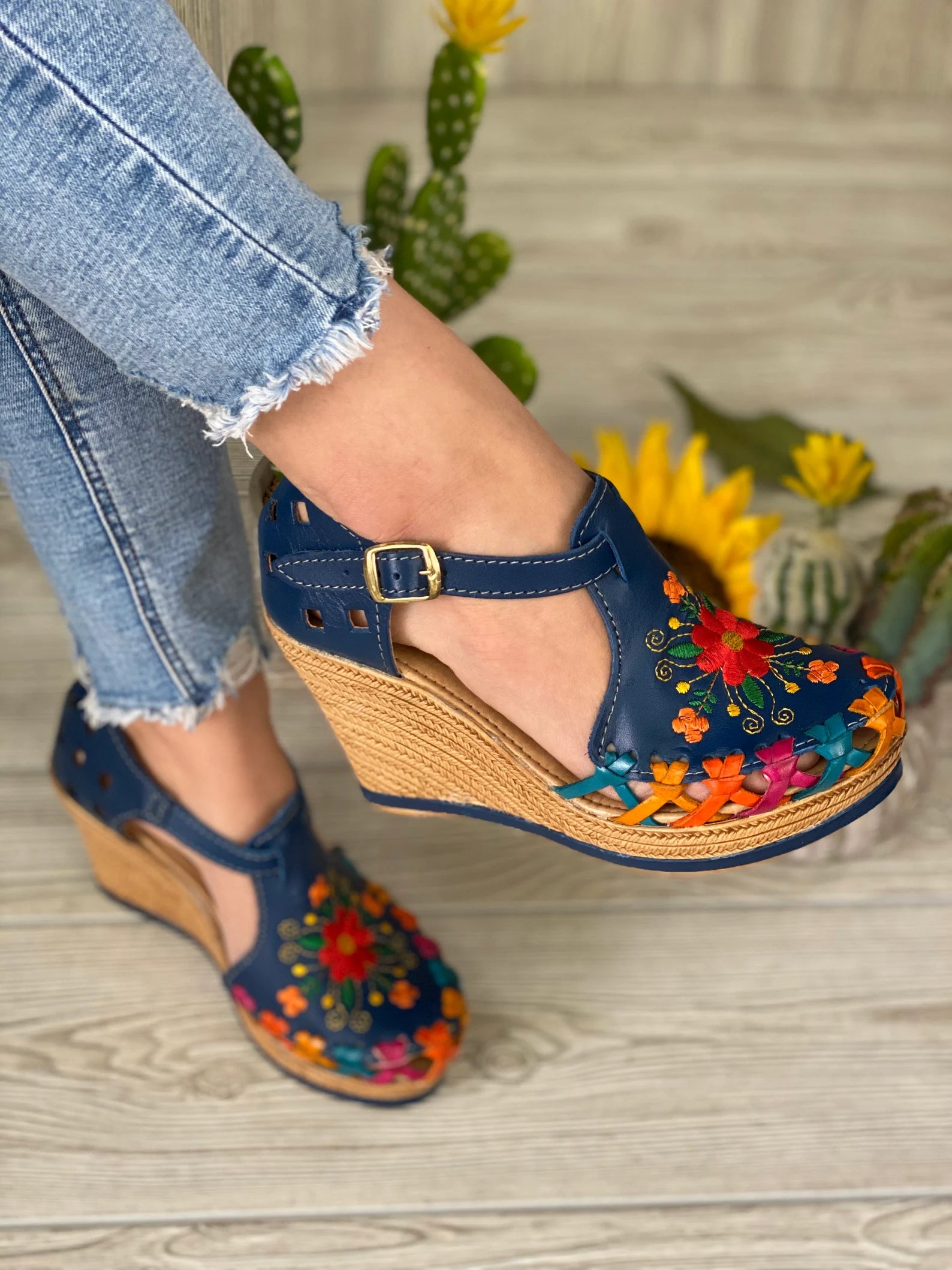 model wearing navy blue leather wedges with colorful embroidery and accents
