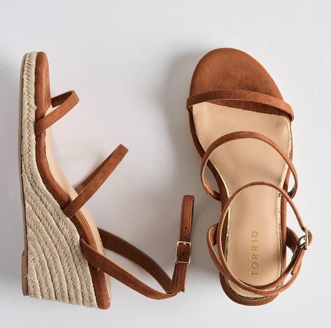 Pair of brownish strappy wedge sandals with a woven platform, showing the marque
