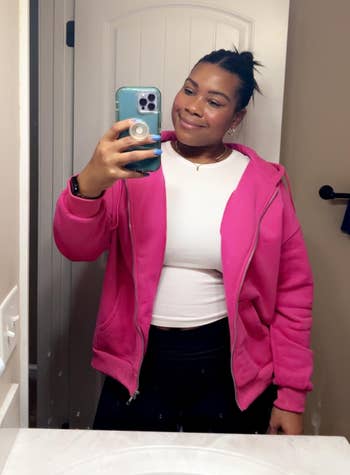 Person takes a reflector selfie wearing a casual pinkish overgarment implicit a achromatic top