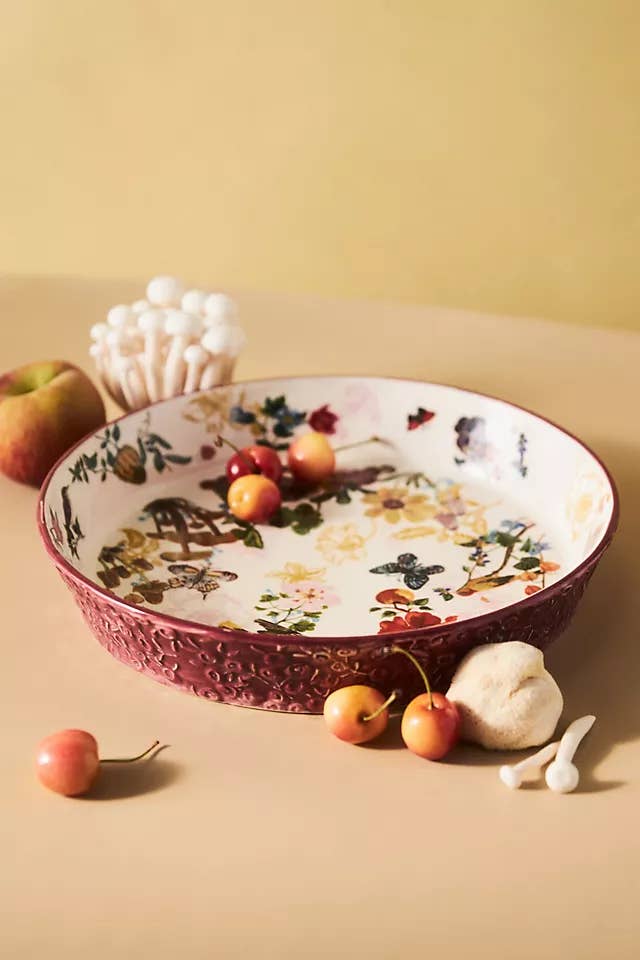 a berry colored pie dish with pretty flowers and butterflies on the bottom