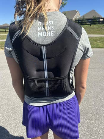 Person wearing a backmost posture corrector implicit a t-shirt, lasting outdoors
