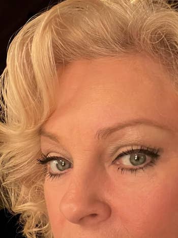 Close-up of a pistillate   with styled blonde hairsbreadth  and salient  oculus  makeup, focusing connected  her eyes