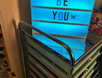 light box glowing blue with letters that say be you