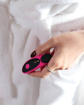 Model holding pink and black panty vibrator
