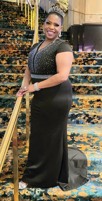 Reviewer wearing long black dress on steps