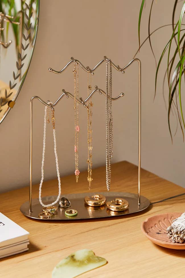 a catchall with two squiggly metal pieces above it to hang chains from