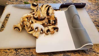 a reviewer's scraper picking up chopped mushrooms