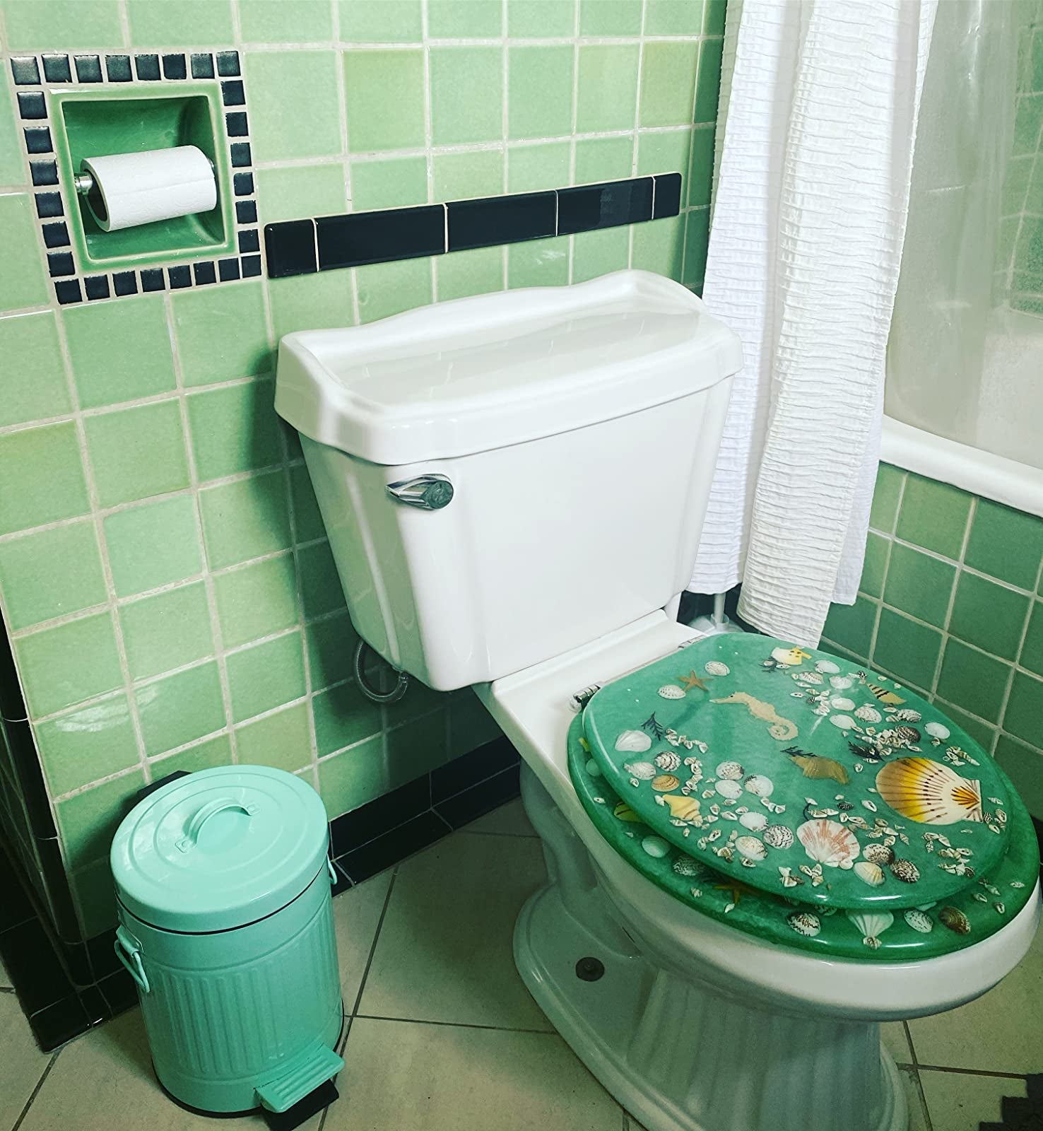 reviewer image of the mint green garbage can in a mint green bathroom