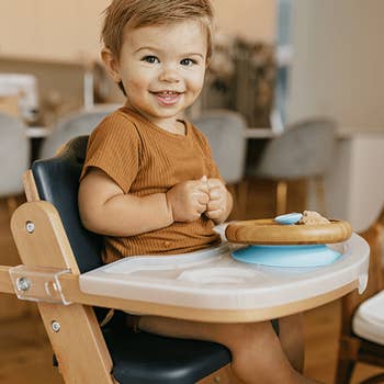 a toddler sitting in a sleek high chair