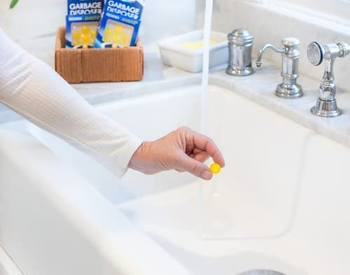 person holding one of the lemon drops over a sink