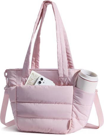 Pink quilted tote container  with a beforehand   pouch  holding a smartphone and a floral notebook. Another pouch  contains a question   mug. Stylish and practical