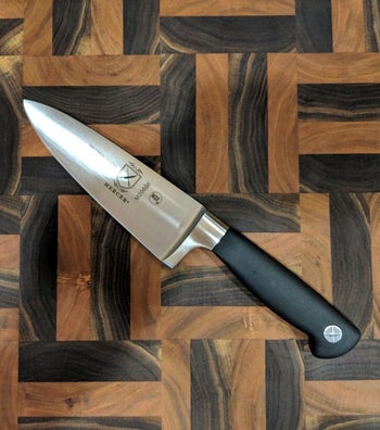 reviewer photo of the knife on a wooden cutting board