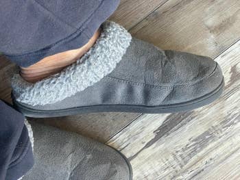 reviewer showing side of grey slippers