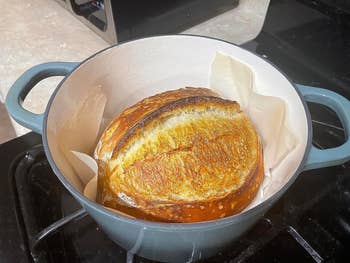 a reviewer's blue dutch oven with bread in it