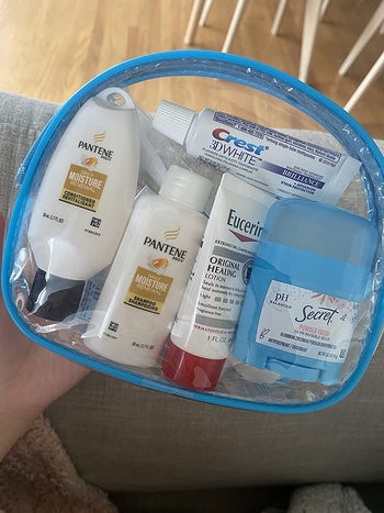 reviewer holding clear bag with blue edges showing everything that comes inside the pack