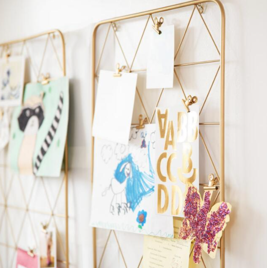 The frame with gold wire triangles with clips holding up cards and pictures