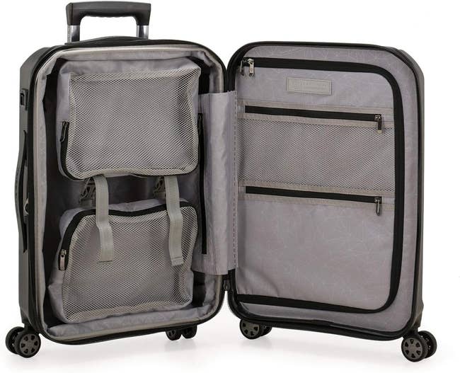 Open four-wheeled suitcase showing interior pockets and compartments