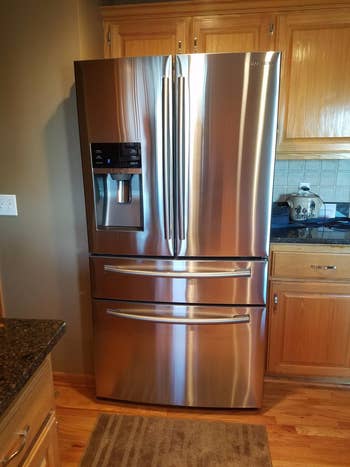 a reviewer's stainless-steel fridge that is shiny after the cleaner and polish is used