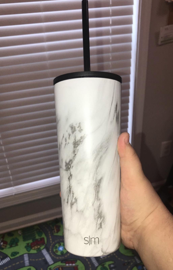 reviewer holding white and gray marble cup