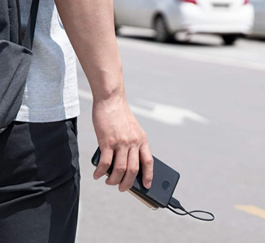 person holding charger and phone together with the phone plugged in