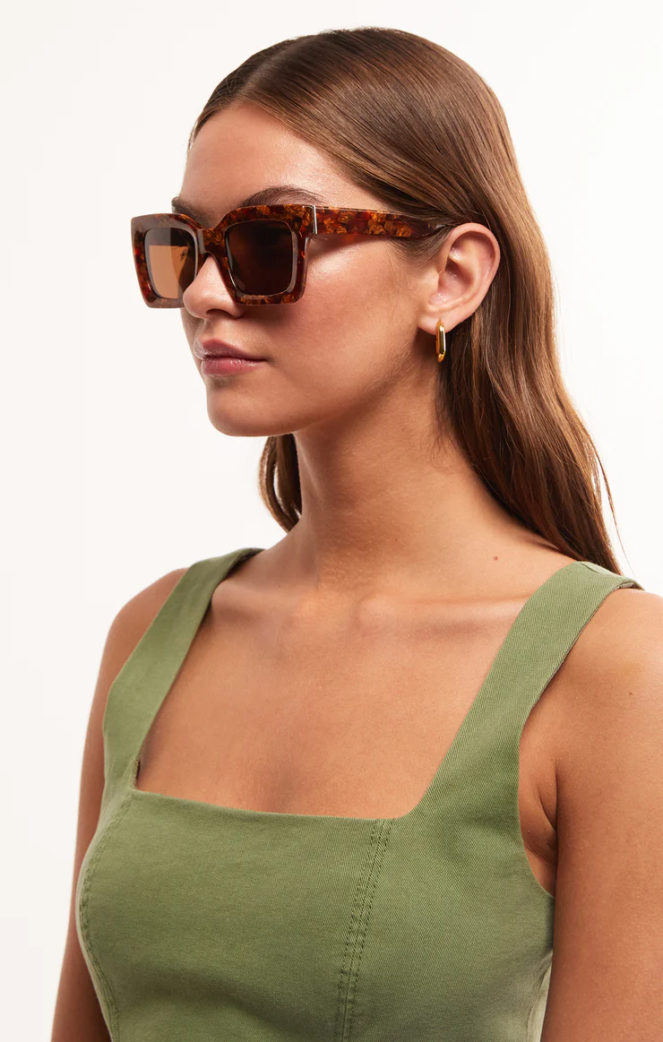 model wearing squared off brown tortoise sunglasses
