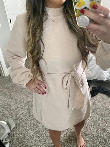 Reviewer is wearing the mock neck sweater dress in a cream color