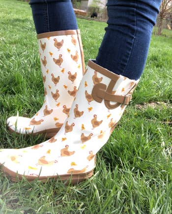reviewer wearing duck printed rain boots