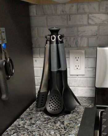 A set of kitchen utensils standing upright in a holder on a countertop