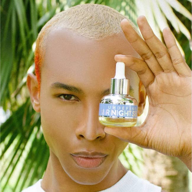 A model holding up the Undefined night serum in front of their face