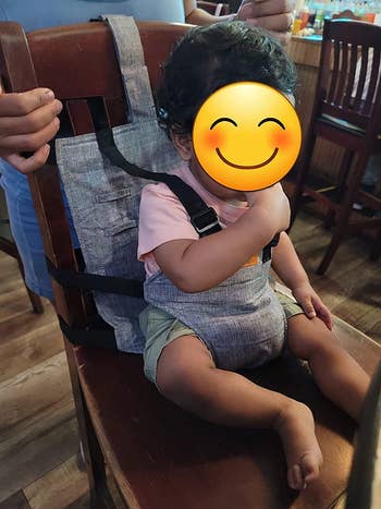 side view of a reviewer's child in the harness seat on a chair