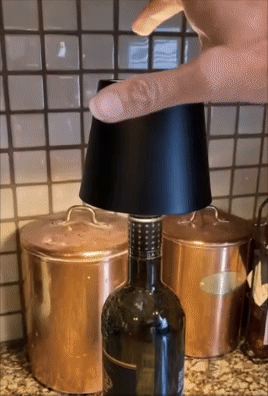 Hand placing a achromatic  detachable vino  accessory connected  a vessel  successful  a room  mounting  with copper containers successful  the background