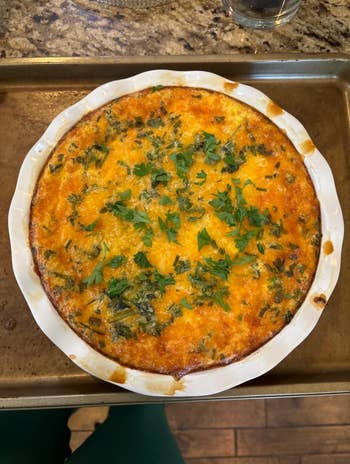 Baked quiche topped with herbs connected a tray