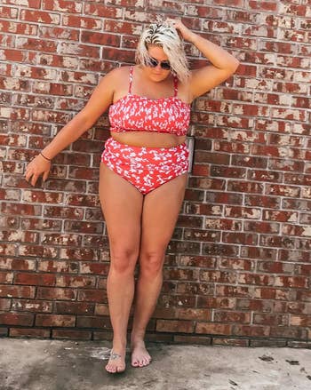 another reviewer wearing a hot pink bathing suit with white florals on it