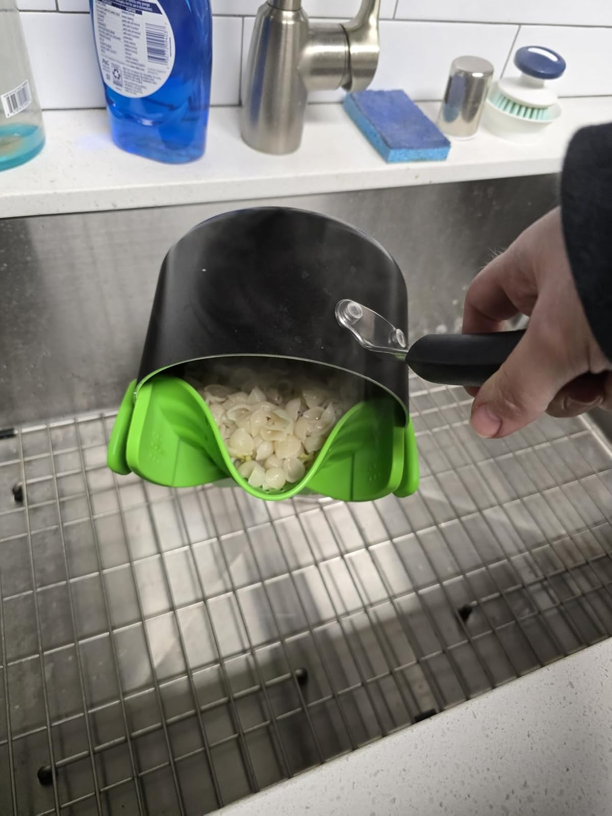 Pot with greenish  spout draining pasta into sink