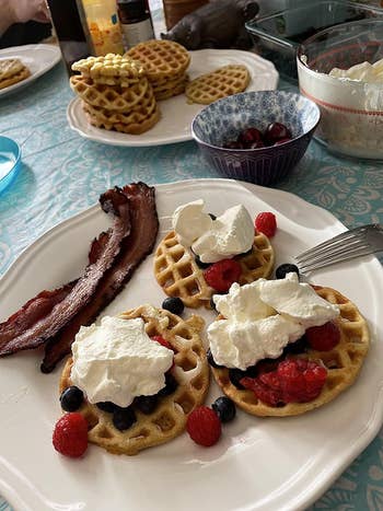 another reviewer photo of three mini waffles on a plate with fruit and whipped cream