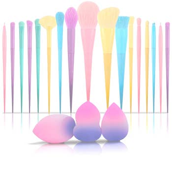 Assorted makeup brushes and blenders arranged in two rows on a reflective surface, essential for beauty enthusiasts